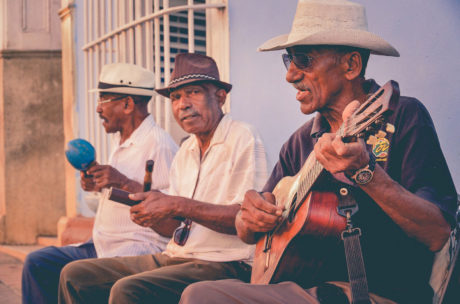 three older adults playing guitars