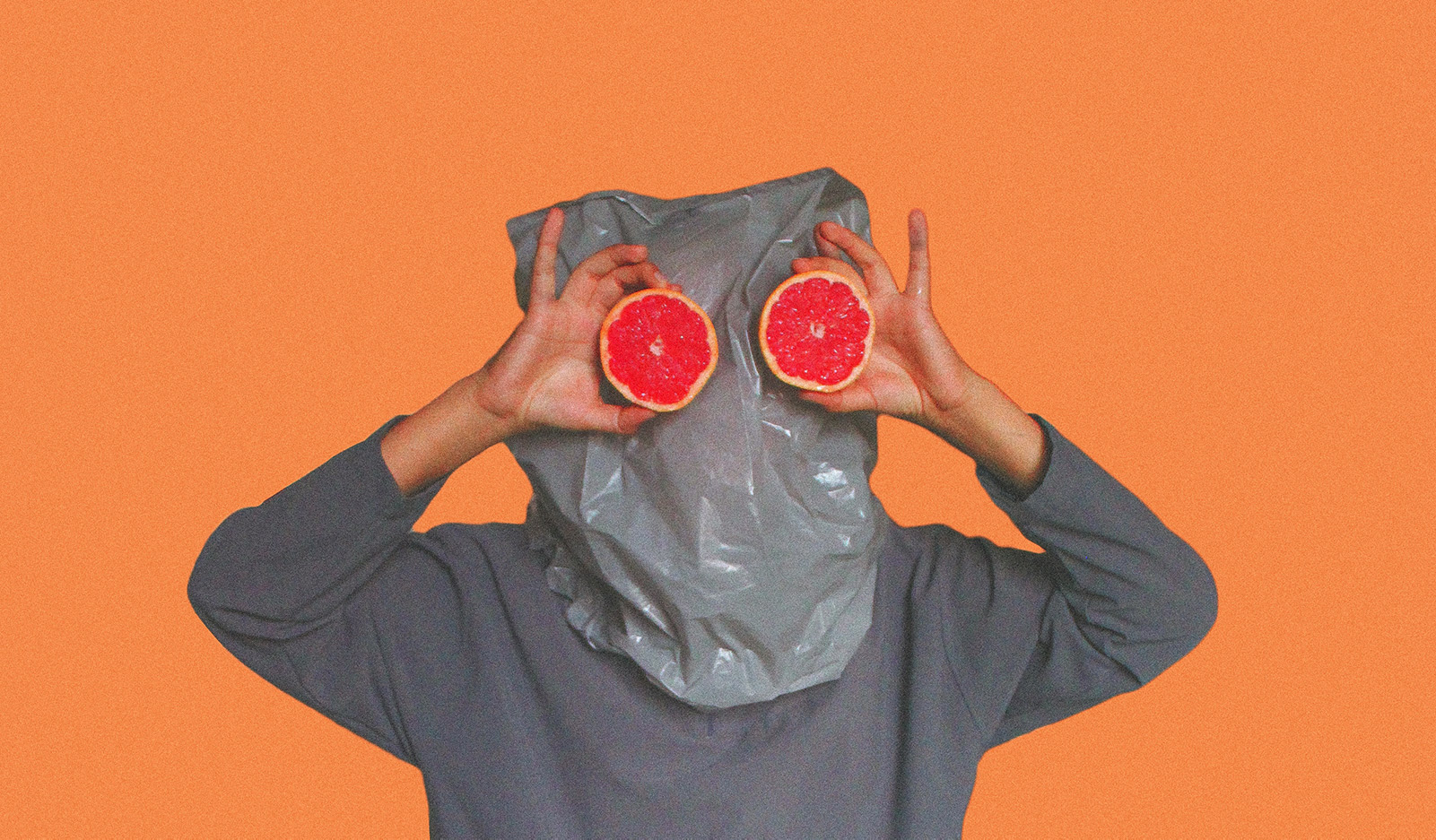 person with bag over head and grapefruits for eyes
