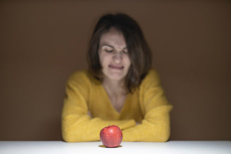 woman disgusted looking at apple