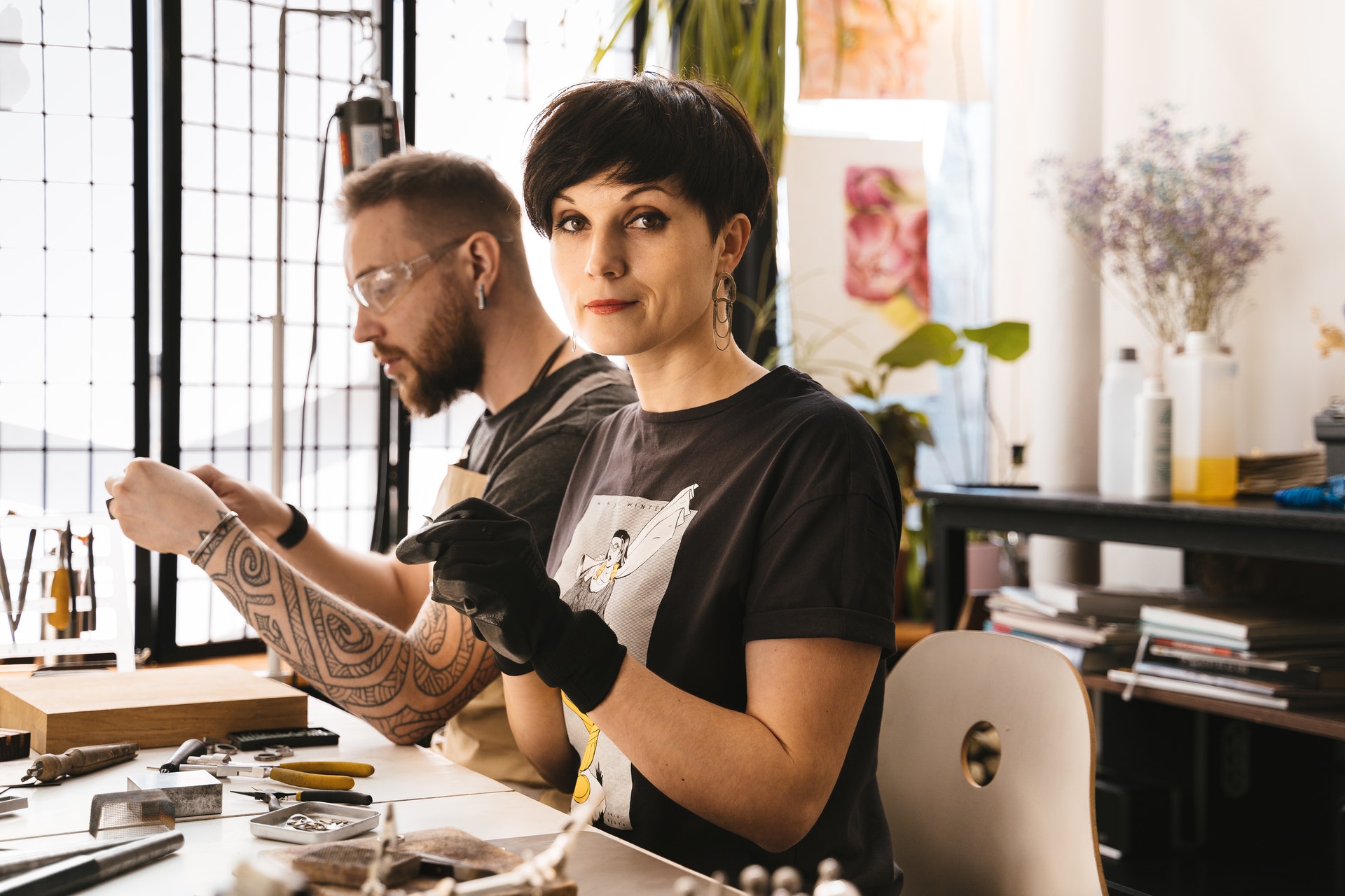 man and woman working at a tattoo studio